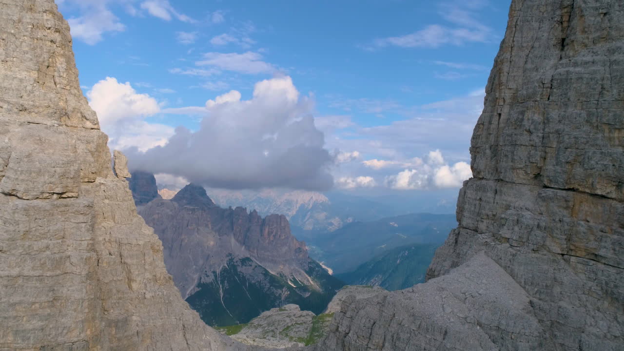 Reverse aerial view blue sky Tre Cime mountain range elevation revealing rock formation peaks