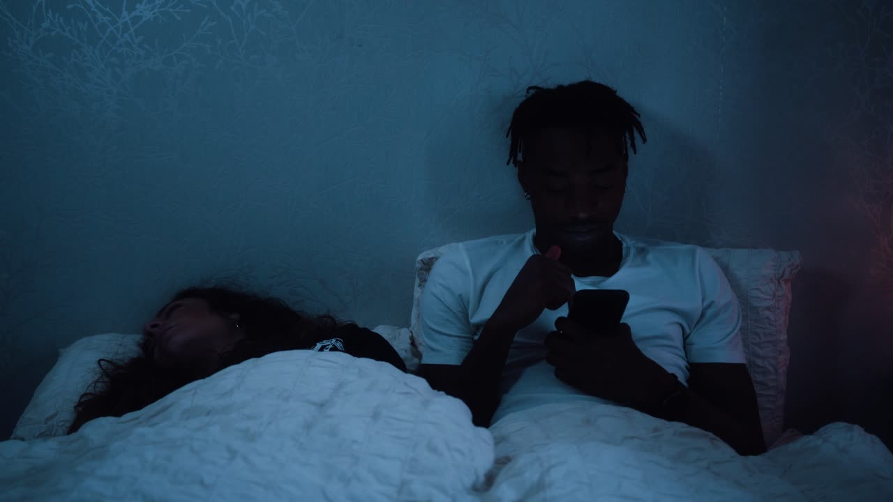 el hombre se sienta hasta tarde en la noche bostezando y frotándose los ojos sintiéndose cansado