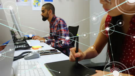 Animation of network of connections with icons over diverse colleagues using computer
