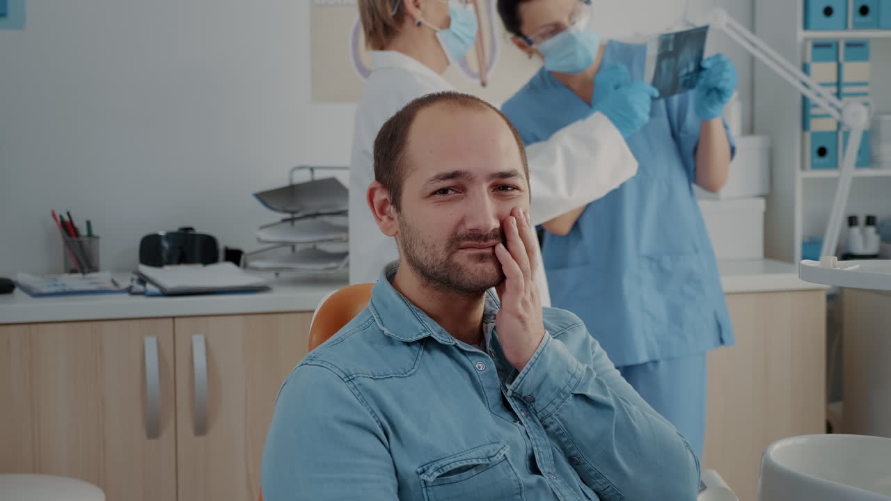 Portrait of patient with toothache looking at camera in dentistry office