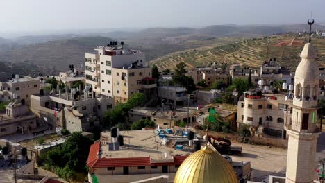 aerial view of a palestinian village with a golden-domed mosque and minaret