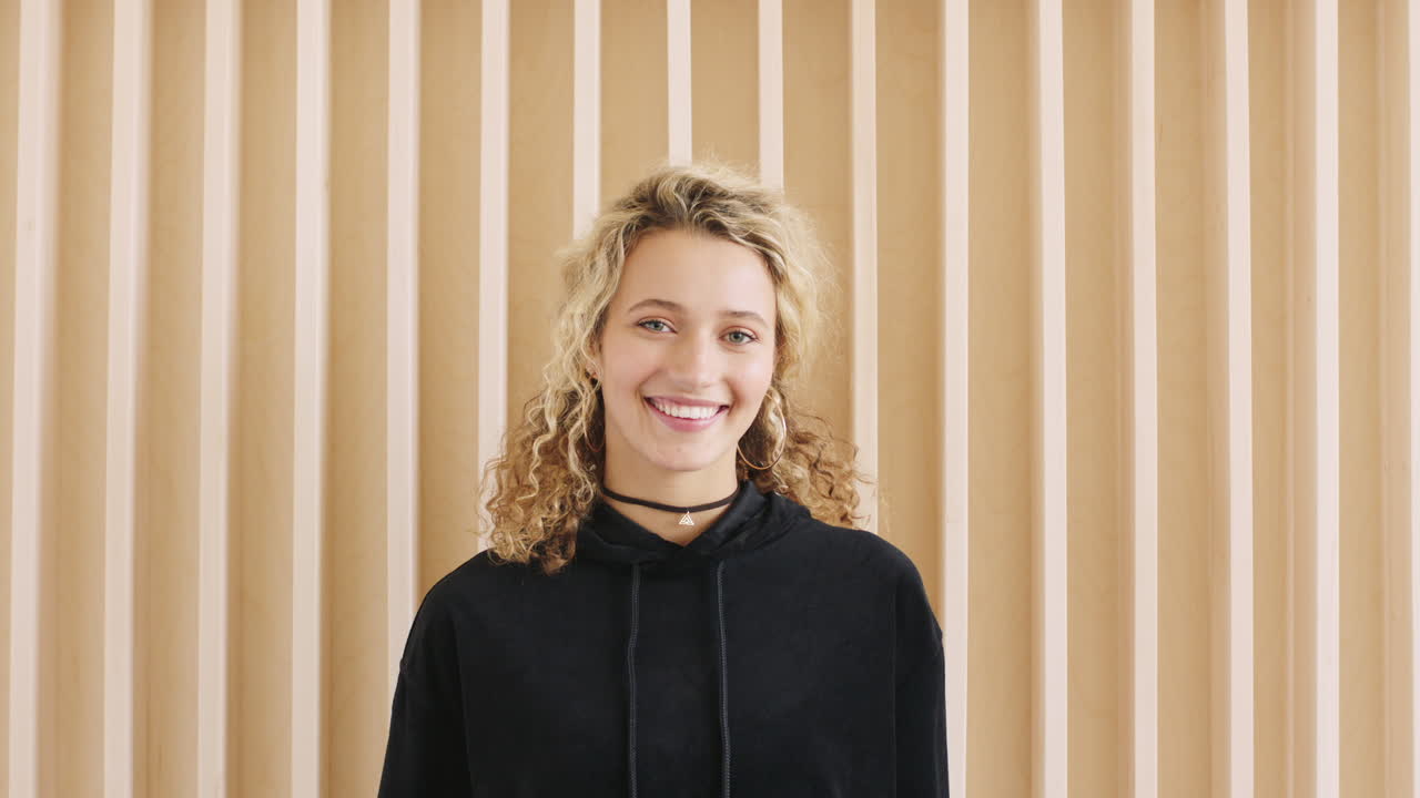 retrato de una mujer feliz, sonriente y a la moda contra