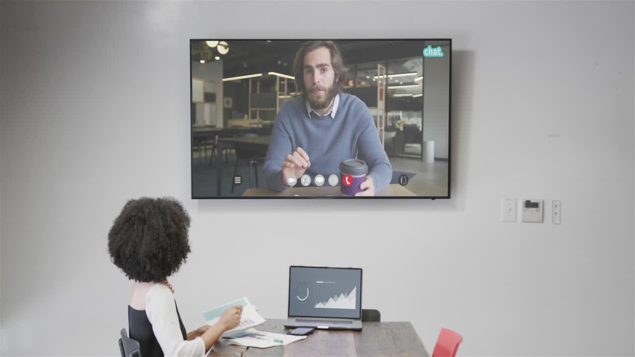 African american businesswoman on video call with caucasian male colleague on screen
