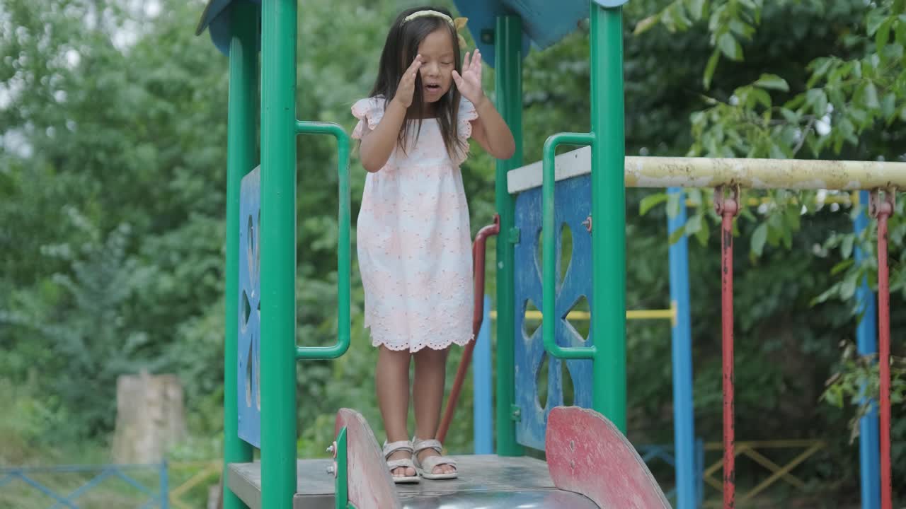 임신 한 어머니 와 어린 딸 은 나무 와 초록색 으로 둘러싸인 공원 의 놀이터 에서 함께 놀이 를 즐긴다