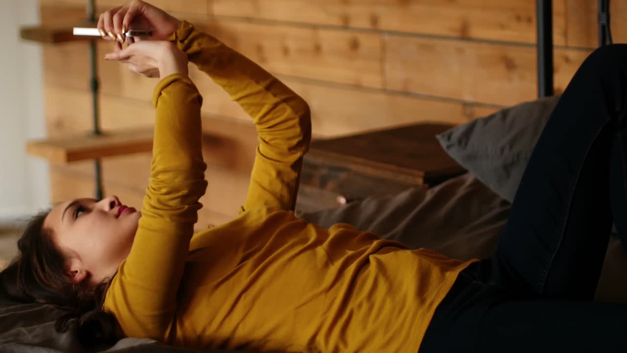 mujer usando teléfono móvil en la cama