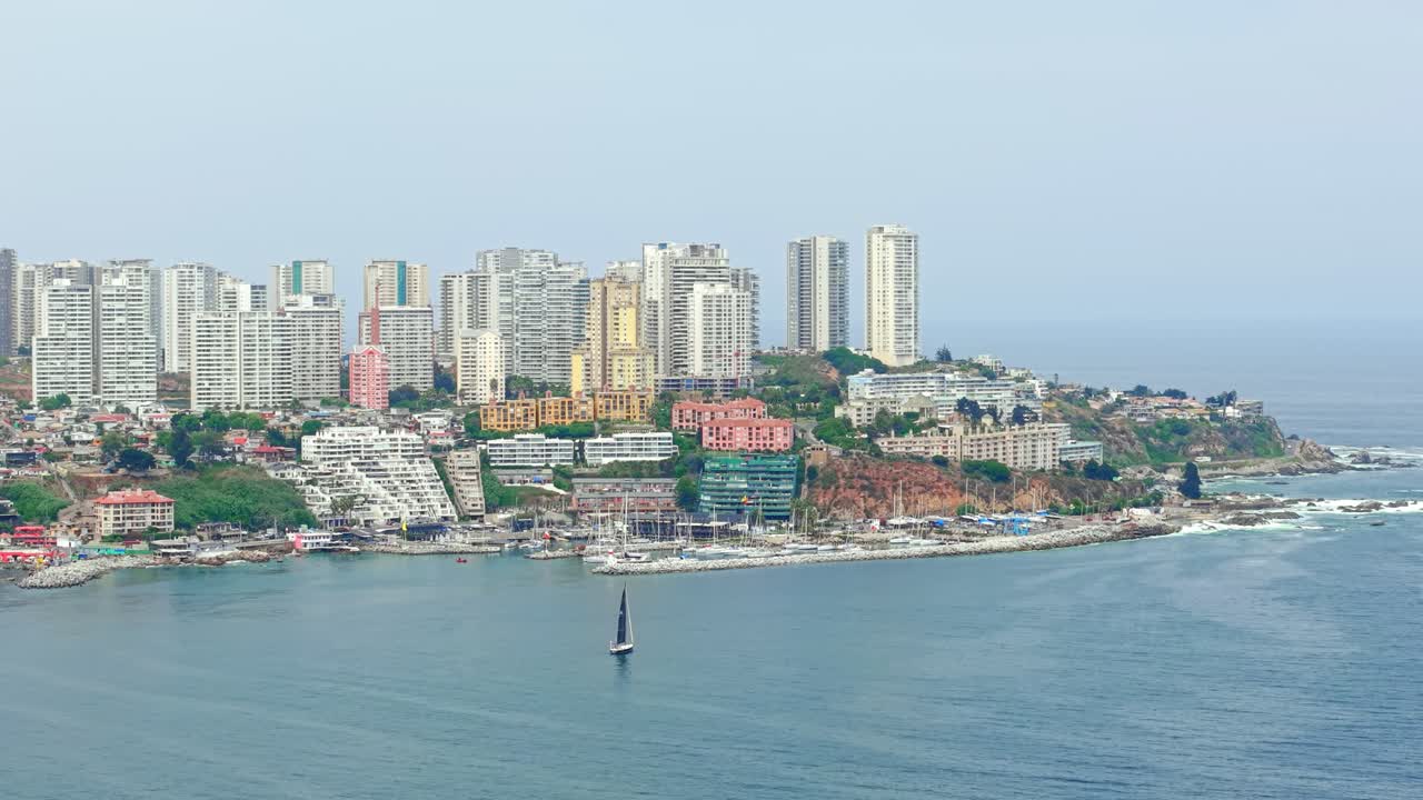 Vista aerea con teleobiettivo degli esclusivi edifici di Concon in una giornata nuvolosa, con una piccola barca sulle sue rive, di fronte allo yacht club, Cile.