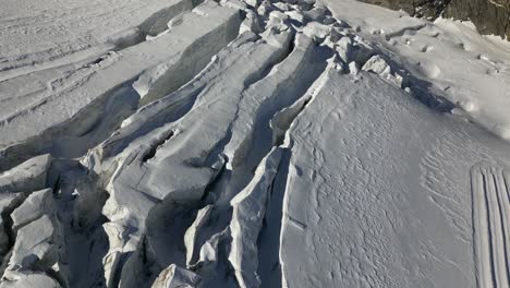 vista aérea de glaciares y grietas, agujeros profundos en la nieve, paisaje invernal en suiza