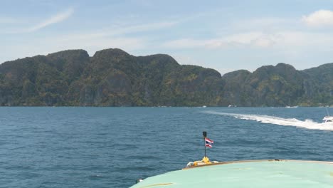 arriving at kho phi phi island on a ferry, with clear blue water and islands in the distance