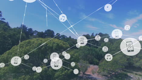 animación de iconos conectados con líneas sobre vista aérea de árboles en campo verde contra cielo nublado