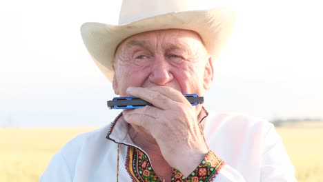 elderly man playing harmonica in traditional attire