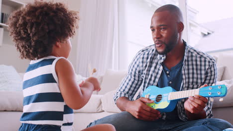 Joven-Padre-Negro-Cantando-Y-Tocando-El-Ukelele-Con-Su-Hija