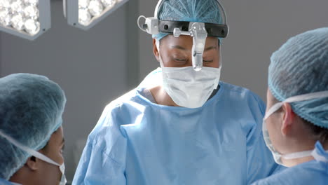 Diverse-female-surgeons-operating-on-patient-in-operating-theatre,-slow-motion