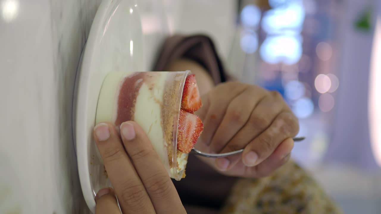 Woman eating strawberry dessert