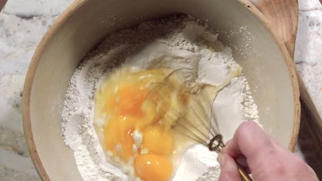 overhead view of whisking eggs into flour