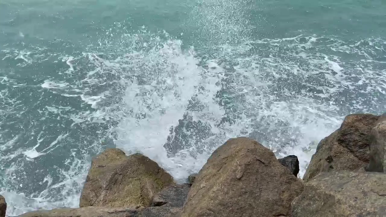 Inquadratura statica di onde che si infrangono sulla costa rocciosa in India