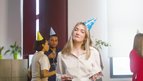 mujer rubia feliz bailando y divirtiéndose en la fiesta de la oficina 1
