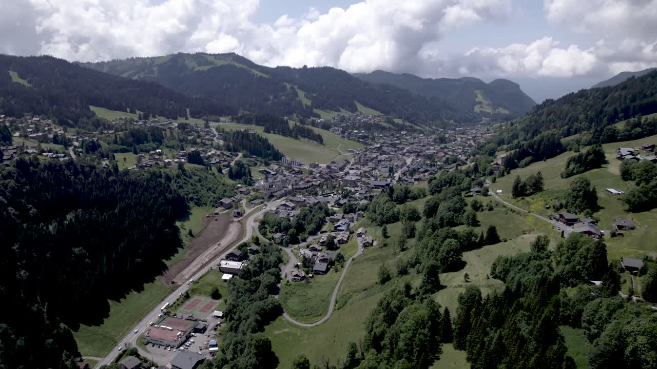 el valle de los alpes franceses con el pueblo de les se ve desde encima de una ladera de la montaña durante el verano