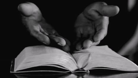 praying-to-God-with-hands-on-bible-on-table-with-people-stock-footage-stock-video