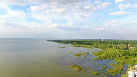 Panorámica-Sobre-Una-Comunidad-Junto-Al-Lago-Para-Revelar-Un-Muelle-Junto-Al-Lago-En-Una-Tranquila-Y-Hermosa-Tarde-De-Primavera