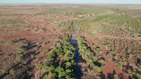 Imágenes-Aéreas-Sobre-Pozos-De-Agua-En-El-Arroyo-Wattie-Con-La-Comunidad-De-Daguragu-Al-Fondo,-Territorio-Del-Norte,-Australia