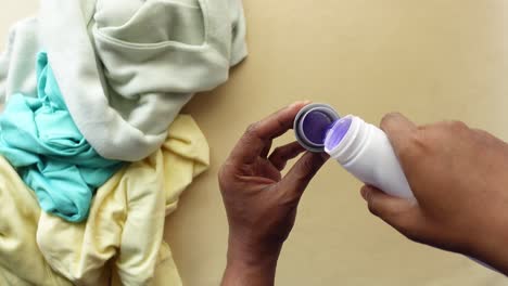 hands pouring laundry detergent into a measuring cup for washing clothes