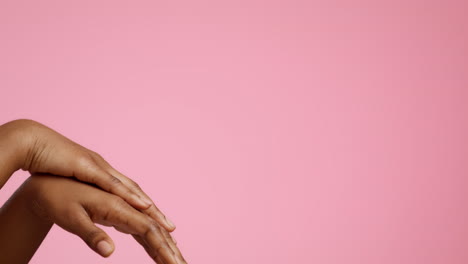 close-up of woman's hands on a pink background