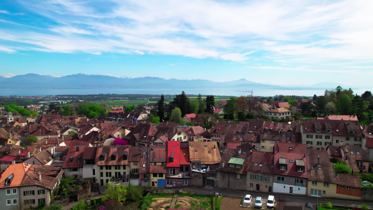 aubonne, suiza, fotografía aérea de los edificios de la ciudad con los alpes franceses y el lago ginebra en el fondo
