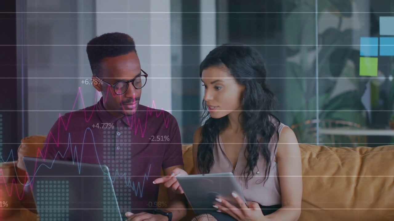 Woman tapping tablet man typing laptop causing finance chart overlay on screens and analyzing data