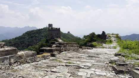 exploring an authentic section of the great wall of china, a man walks atop the ancient structure