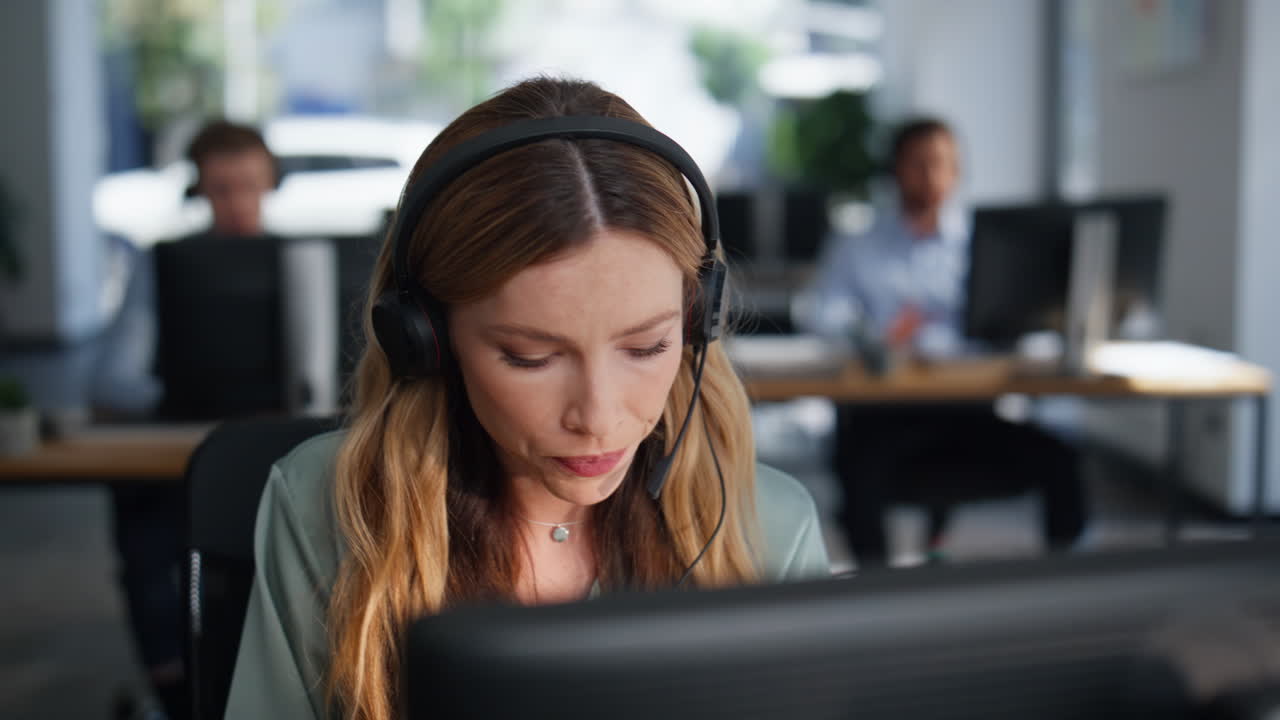 Tech support operator helping client wearing headset in office space closeup