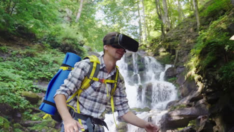 A-Person-In-A-Virtual-Reality-Helmet-Against-The-Backdrop-Of-A-Beautiful-Waterfall