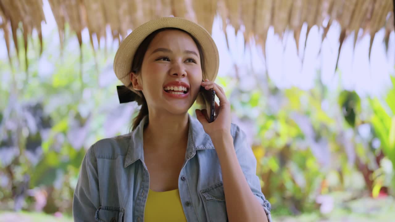 work and vacation asian female digital nomad millennial lifestyle hand hold smartphone conversation with abroad client distance meeting,asian female casual cloth walking speaking on the beach ocean