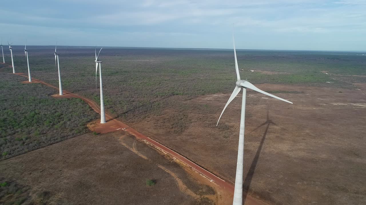 drone filming in a wind farm approaching a machine with lateral movement and very soft light, northeastern brazil