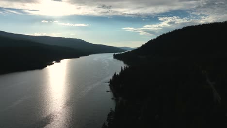 Glimmering-River-Water-With-Forested-Valley-In-Silhouette-At-Dusk-In-Eureka,-Montana,-USA