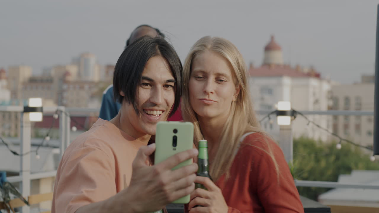Friends Taking a Selfie at a Rooftop Party