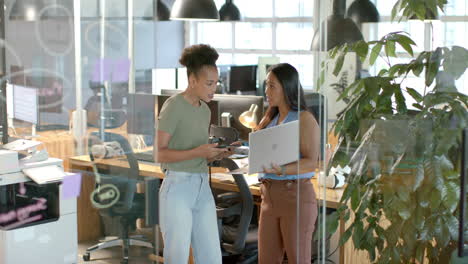 young african american woman discusses with biracial woman in a modern office