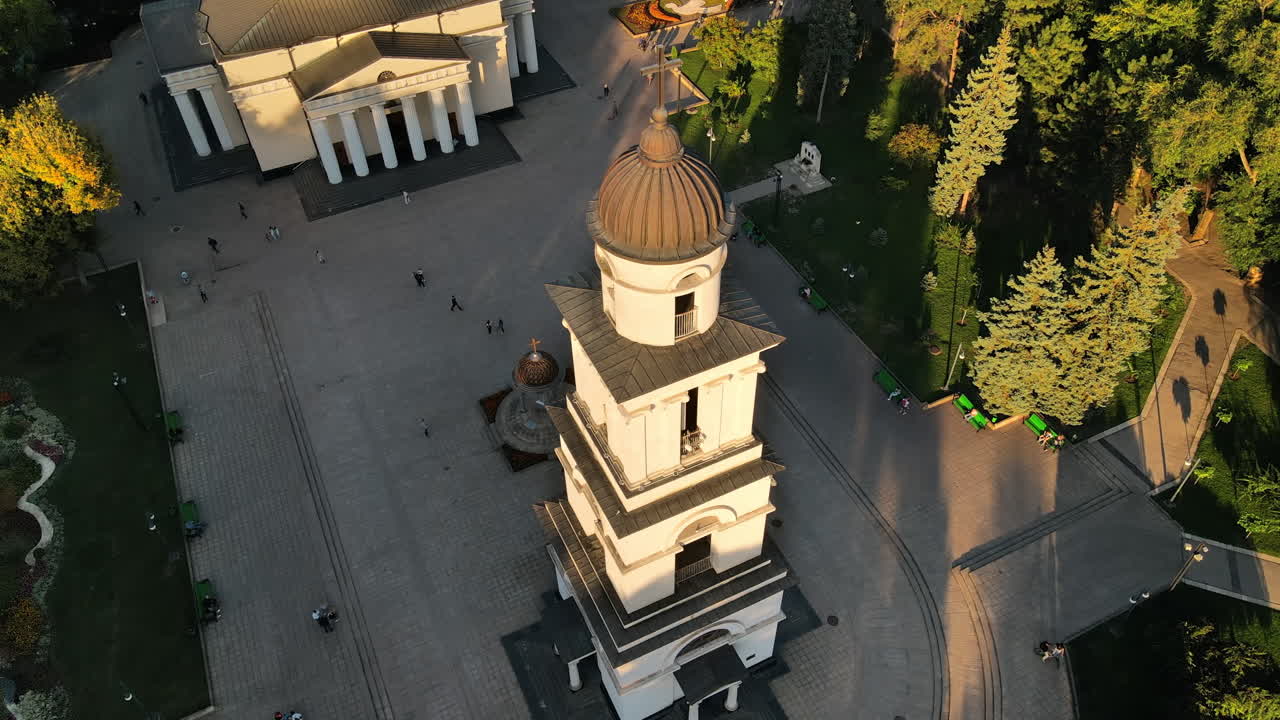 Aerial drone view of Chisinau downtown at sunset. View of central park, Cathedral, bell tower, a lot of greenery, walking people. Moldova