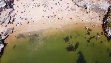 aerial top down view descending shot of rainha beach in cascais, portugal