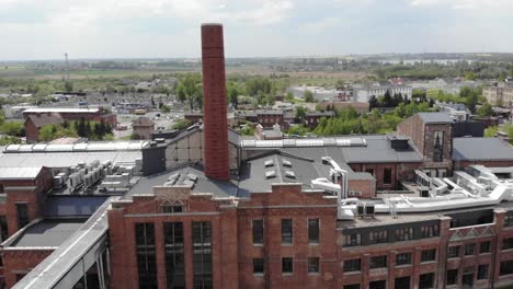 aerial slow orbit shot of the chimney in arche hotel żnin inside old sugar factory in poland