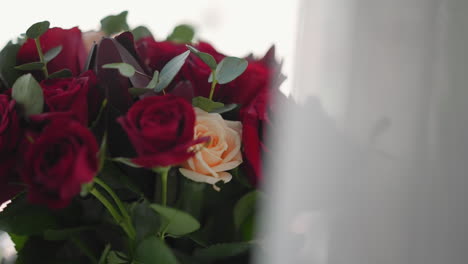 pretty bouquet of red roses and eucalyptus in light room