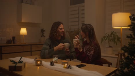 couple enjoying hot drinks and celebrating christmas