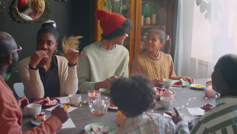family eating dessert and taking at holiday dinner