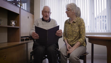 elderly couple reading a book together at home