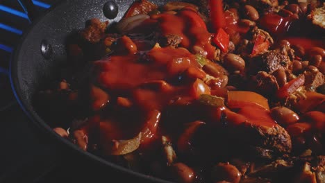 tomato sauce pouring into spicy chicken bean cooking in pan