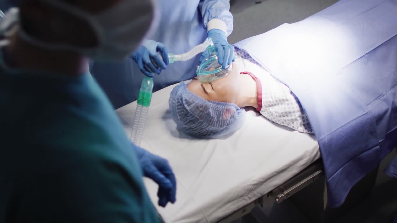 video de la sección media del asistente quirúrgico dando gas a una paciente asiática en el quirófano