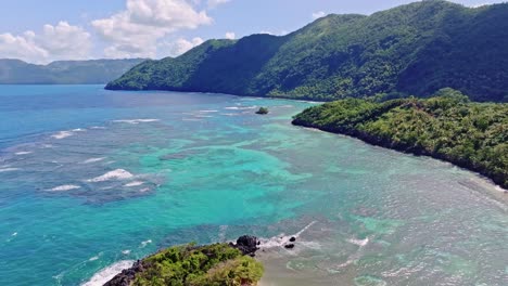 aerial over idyllic dominican coastline with shallow coral reef, playa ermitano