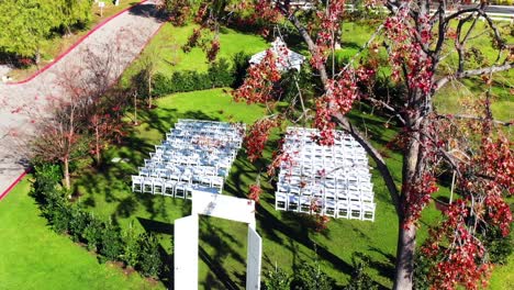 aerial drone descending shot passing by trees showing an outdoor wedding venue