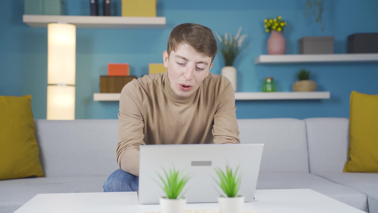 노트북에서 보는 것에 대해 화를 내는 젊은 남자.