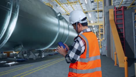 ingeniero inspeccionando un gran contenedor en una fábrica