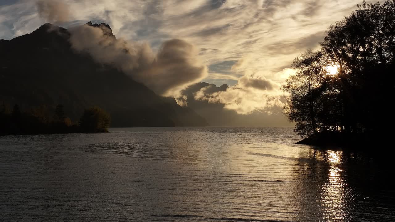 Sunset over a Calm Lake with Mountains in the Background